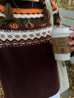 a woman holding a cup of coffee in her hand