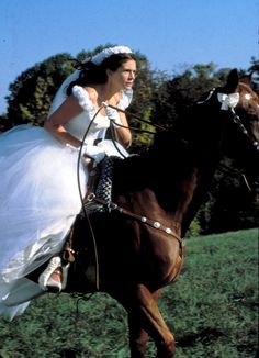 a bride riding on the back of a brown horse