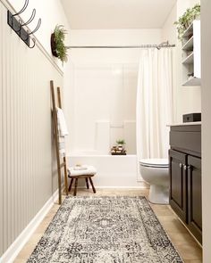 a bathroom with a rug, toilet and bathtub