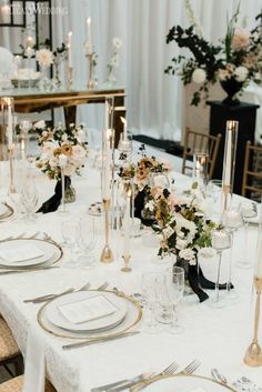 the table is set with white and gold place settings