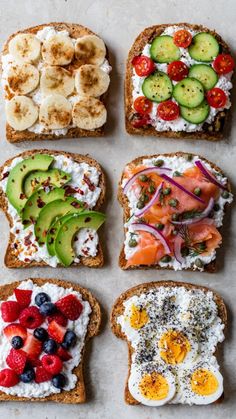 four slices of bread with different types of food on top of each other, including eggs, fruit and cucumbers