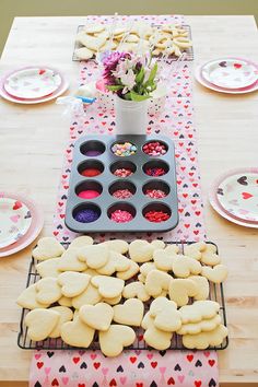 a table topped with lots of cookies and cupcakes