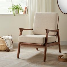 a chair sitting in front of a window next to a basket with a plant on it