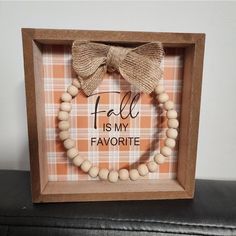 a wooden frame with a wood bead and bow on it that says fall is my favorite