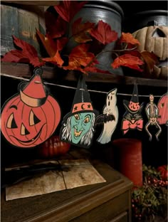 halloween decorations are hanging on a shelf in front of some pumpkins and other items