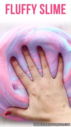 a person's hand on top of a pink and blue slime doughnut