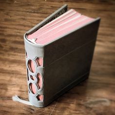 an open book sitting on top of a wooden table next to a pair of scissors