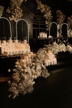 flowers and candles are arranged in rows on the floor next to each other with mirrors behind them