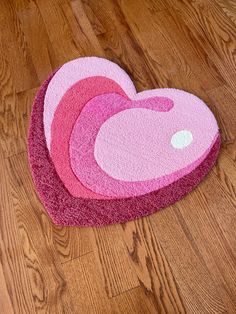 three heart shaped rugs sitting on the floor in front of a wooden flooring