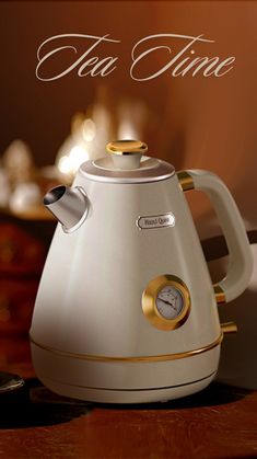 a white tea kettle sitting on top of a wooden table