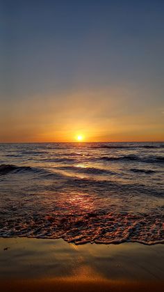 the sun is setting over the water at the beach