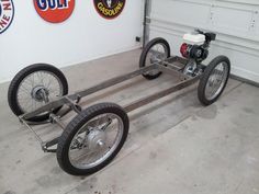 a motorcycle is attached to a cart in a garage with two tires on the front