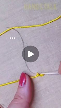 someone is working with yellow thread on a piece of fabric that has been stitched together