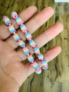 a hand holding four colorful beads in it's palm