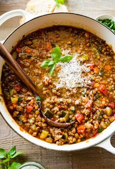 a large pot filled with soup on top of a wooden table