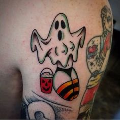 a man with a ghost tattoo on his arm holding a candy bar and popcorn bucket