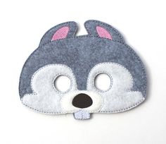 a gray and white animal mask with pink ears on it's face, made out of felt