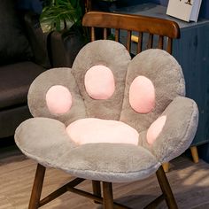 a chair that is shaped like a flower with four petals on the back and three pink spots on the front