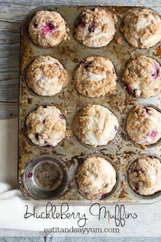 muffins with blueberries and crumbled toppings on a baking sheet