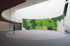 a person standing in front of a large painting