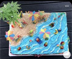 there is a cake that looks like it has beach scenes on it and umbrellas in the sand