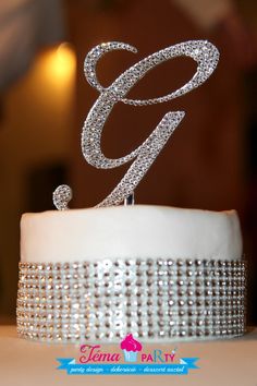 a wedding cake with the letter g on top