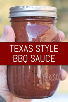 a hand holding a mason jar filled with bbq sauce and the words texas style bbq sauce