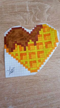 a piece of paper that has been made to look like a heart with yellow and brown squares on it