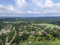 an aerial view of a golf course with houses and trees