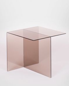 a square glass table with no top on a plain white surface in front of a light colored background