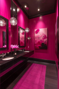 a pink bathroom with two sinks and mirrors