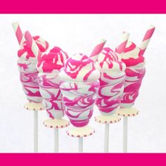 pink and white swirl covered candy pops on top of each other with straws sticking out of them