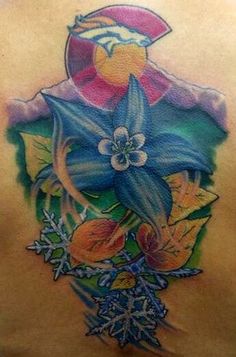 the back of a woman's tattoo with flowers and leaves on her chest,