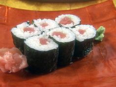 sushi rolls on a red plate with chopsticks