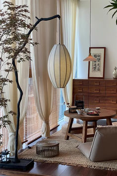 a living room filled with furniture next to a tall tree in front of a window