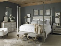 a bedroom with gray walls and white furniture, including a four poster bed in the center