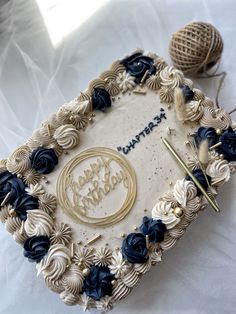 a birthday cake is decorated with blue flowers and gold letters that spell out happy birthday