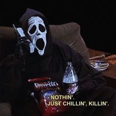 a person wearing a mask sitting on a couch with two sodas in front of them