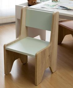 a wooden chair sitting in front of a desk with a teddy bear on top of it