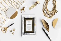 a tablet with save the date cards on it next to other items and gold accessories