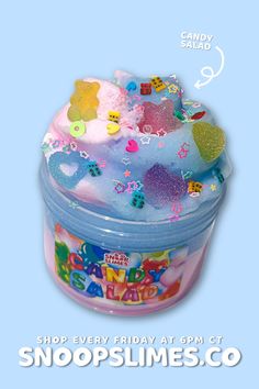 a small plastic container filled with lots of colorful candies on top of a blue background