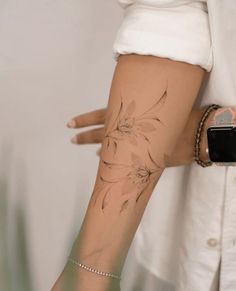 a woman's arm with a flower tattoo on the left side of her arm