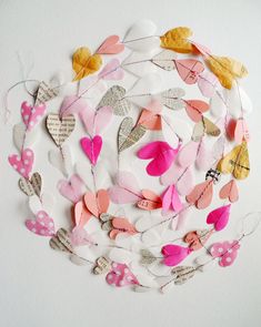 paper butterflies are arranged in a circle on a white surface with pink and yellow accents