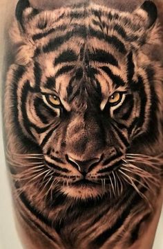 a close up of a tiger's face on the back of a man's leg