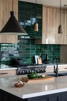 a kitchen with wooden cabinets and green tile backsplash, hanging lights over the stove