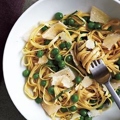 a white bowl filled with pasta and peas