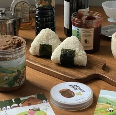 sushi on a cutting board next to other foods and condiments