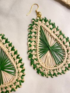 the green and white earrings are made out of woven rafts, with leaves on them