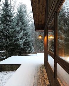 a porch with snow on the ground and trees in the backgroung area