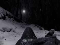 a person laying down in the snow with their feet propped up on it's side